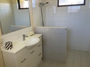 a white bathroom with a sink and a mirror at Unit 16, 2 Casuarina Crescent, Ocean Beach Chalets in Jurien Bay
