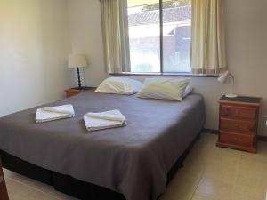 a bedroom with a bed with two towels on it at Unit 16, 2 Casuarina Crescent, Ocean Beach Chalets in Jurien Bay