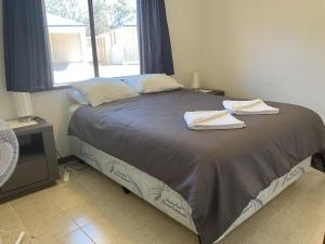 a bedroom with a bed with towels on it at Unit 16, 2 Casuarina Crescent, Ocean Beach Chalets in Jurien Bay