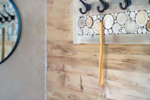 a mirror hanging on a wall with a wooden stick at Bergchalet 3 in Freyung +19 photos