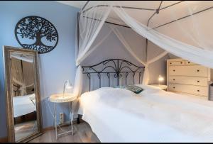 a bedroom with a canopy bed and a mirror at Haus Laffina in Büsum