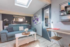 a living room with a blue couch and a table at Studio 404 in Le Muy