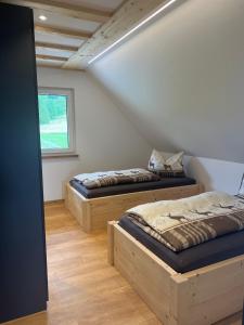 two beds sitting in a room with a window at Ferienhaus am Kapellenhof in Triberg
