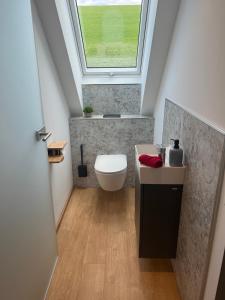 a bathroom with a toilet and a window at Ferienhaus am Kapellenhof in Triberg +37 photos