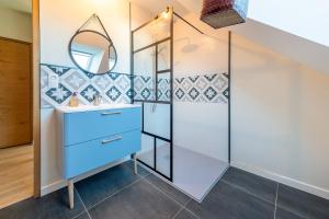 a bathroom with a blue vanity and a mirror at Gite Familiale ty laouen in Sarzeau +24 photos