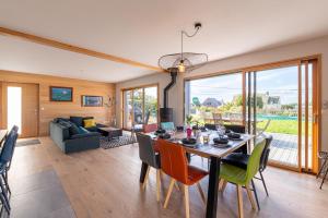 a dining room with a table and chairs and a living room at Gite Familiale ty laouen in Sarzeau