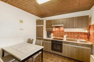 a kitchen with wooden cabinets and a table and a table and chairs at Ferienwohnung Wallisch in Schotten