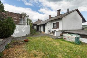 a backyard of a white house with a yard at Ferienwohnung Wallisch in Schotten