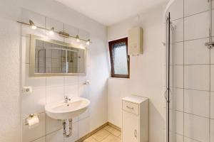 a white bathroom with a sink and a shower at Ferienwohnung Wallisch in Schotten +13 photos