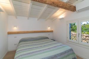 a bedroom with a bed and a window at Villa Cactus, Costa Corallina in Olbia