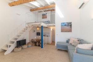 a living room with a blue couch and a staircase at Villa Cactus, Costa Corallina in Olbia