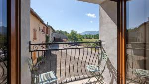 a balcony with two chairs and a view of a street at Maison - Chez Louisette in Espezel +14 photos