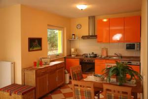 a kitchen with orange cabinets and a table and chairs at Ferienwohnung Melosine in Koserow
