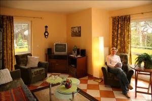 a woman sitting in a chair in a living room at Ferienwohnung Melosine in Koserow +17 photos