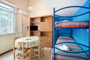 a room with a table and a bunk bed at Monolocale con soppalco 43 in Albenga +21 photos