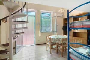 a room with a table and a bunk bed at Monolocale con soppalco 43 in Albenga