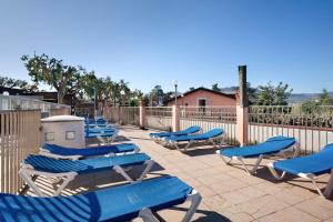 a row of blue lounge chairs on a patio at Monolocale con soppalco 43 in Albenga