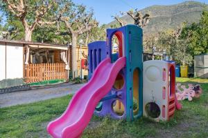 a playground with a slide in the grass at Monolocale con soppalco 43 in Albenga
