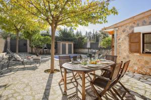 a patio with a table and chairs and a tree at Ca'n Doi in Sóller