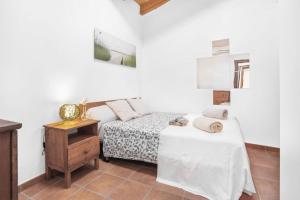 a bedroom with a bed and a nightstand with a table at Ca'n Doi in Sóller +14 photos