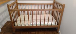 a wooden crib with a mattress in a room at Chambres D'hôtes Les Préaux - in Cérans-Foulletourte