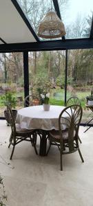 a table with two chairs and a potted plant on it at Chambres D'hôtes Les Préaux - in Cérans-Foulletourte