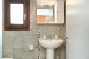 a bathroom with a sink and a mirror at Thea home Symi in Symi