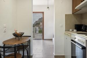 a kitchen with a table and two stools in it at Thea home Symi in Symi +23 photos