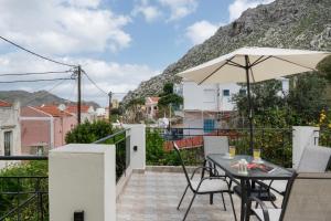 a balcony with a table and an umbrella at Thea home Symi in Symi