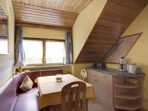 a kitchen with a table and a small table and a table and a table at Gasthaus Zur Linde Ferienwohnungen in Oberharmersbach