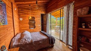 a bedroom with a bed in a wooden cabin at Ecoparque Hotel El Cielo Cabañas in Carmen de Viboral