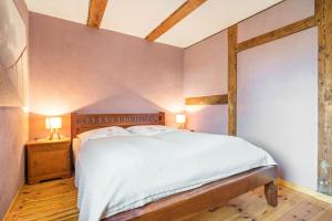 a bedroom with a large bed with white sheets at Kleiner Eselhof in Semlow