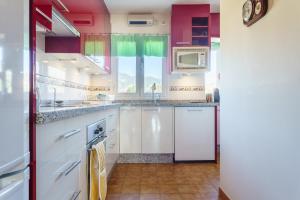 a kitchen with white cabinets and a window at Apartamento Lance del Sol in Fuengirola