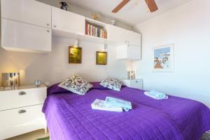 a purple bed in a bedroom with white cabinets at Apartamento Lance del Sol in Fuengirola +12 photos