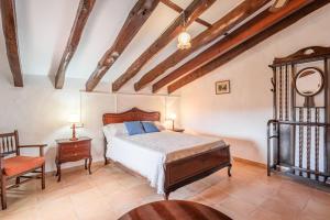 a bedroom with a bed and a chair at Son Galileu in Llucmajor