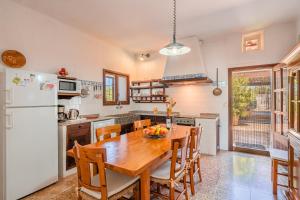 a kitchen with a wooden table and a refrigerator at Son Galileu in Llucmajor