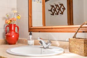 a bathroom sink with a red vase and a mirror at Son Galileu in Llucmajor +17 photos