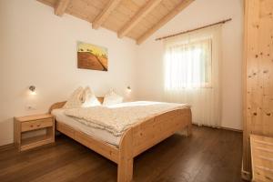 a bedroom with a bed and a window at Pföslhof in Laives