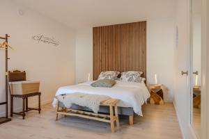 a bedroom with a large white bed with a wooden headboard at Natür'Gîte in Fellering