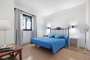 a bedroom with a blue bed and a desk and a window at La Casa De Los Sueños in Corralejo +19 photos