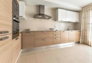 a kitchen with wooden cabinets and a stove at Villa in Amarilla Golf in San Miguel de Abona