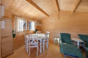a dining room with a table and chairs in a cabin at Ferienhof Harrsen in Pellworm