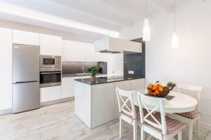 a kitchen with white cabinets and a table and chairs at Es Raco in Costitx