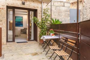 a patio with a table and chairs in front of a building at Es Raco in Costitx