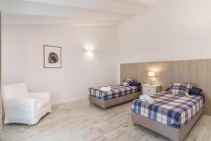 a room with two beds and a chair in it at Es Raco in Costitx