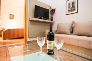 una botella de vino y dos copas de vino en una mesa en Apartments Sofija, en Budva