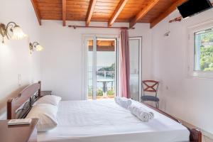 a bedroom with a bed and a large window at Alex bar apartments in Parga +143 photos