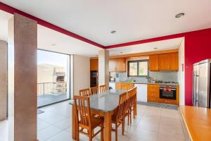 a kitchen with a table and chairs and a large window at Casa de Balinhas - Gerês in Ventosa