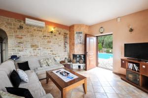 a living room with a couch and a tv at Villa Casa Bianca Blue Apartment in Gaios