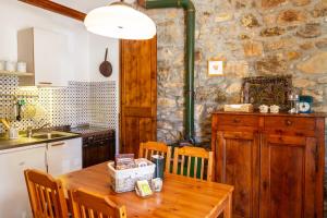 a kitchen with a wooden table and a stone wall at Birbina - Poggio alle Birbe in Il Bagno +22 photos